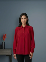 Woman wearing a red shirt standing against a gray background