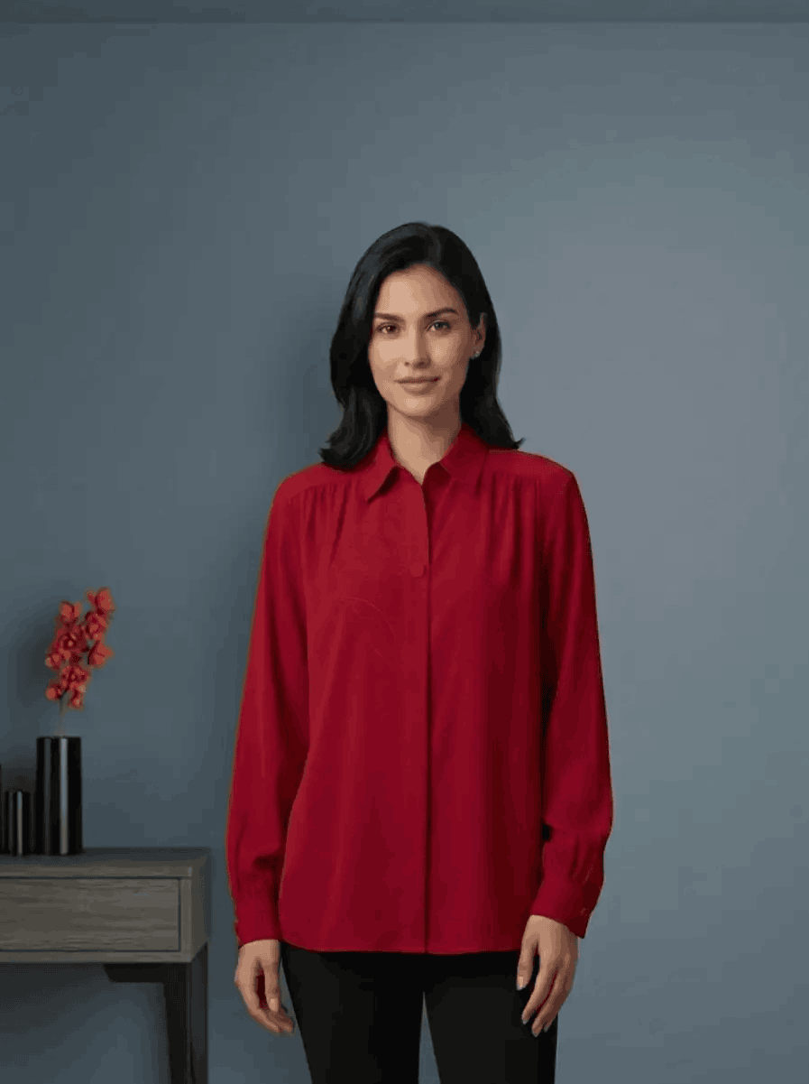 Woman wearing a red shirt standing against a gray background