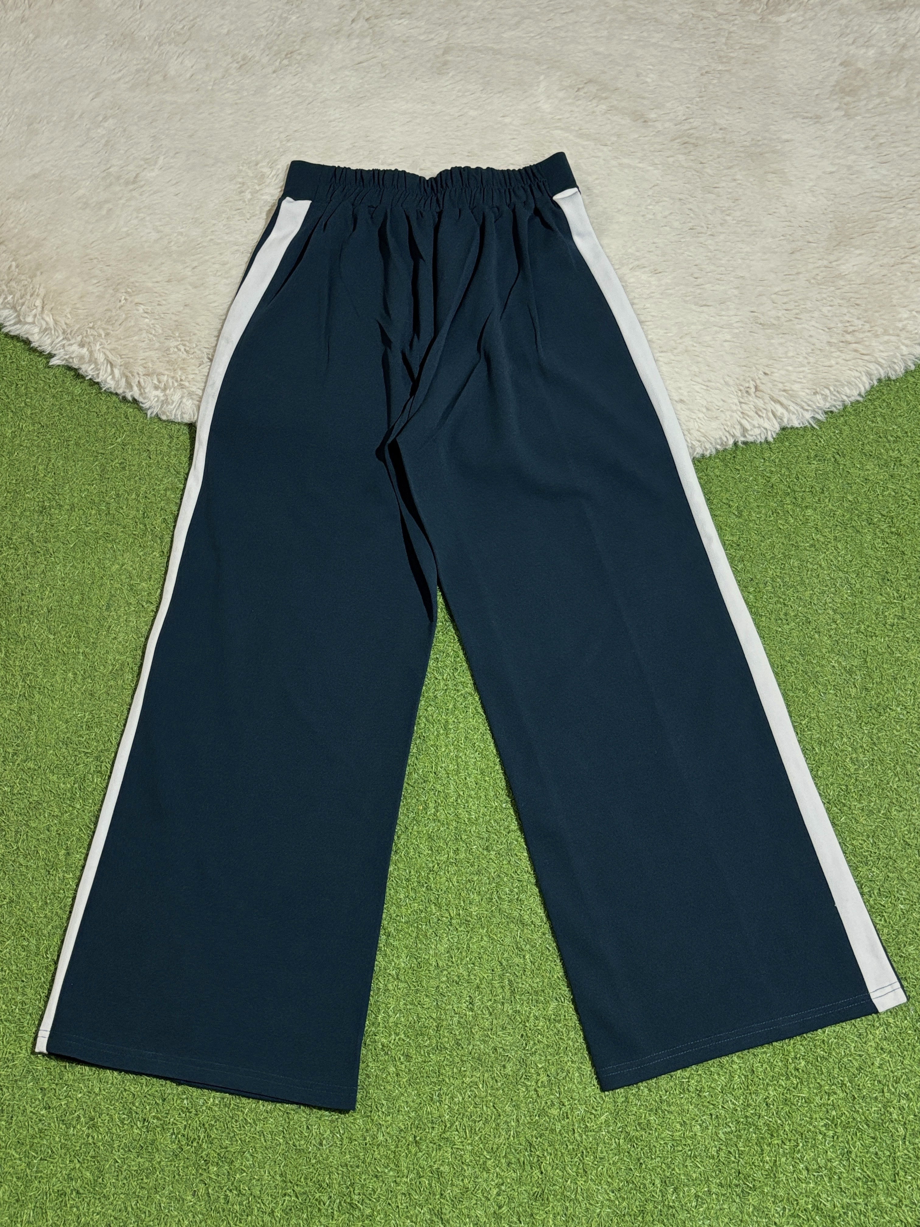Navy blue trousers with white side stripes laid flat