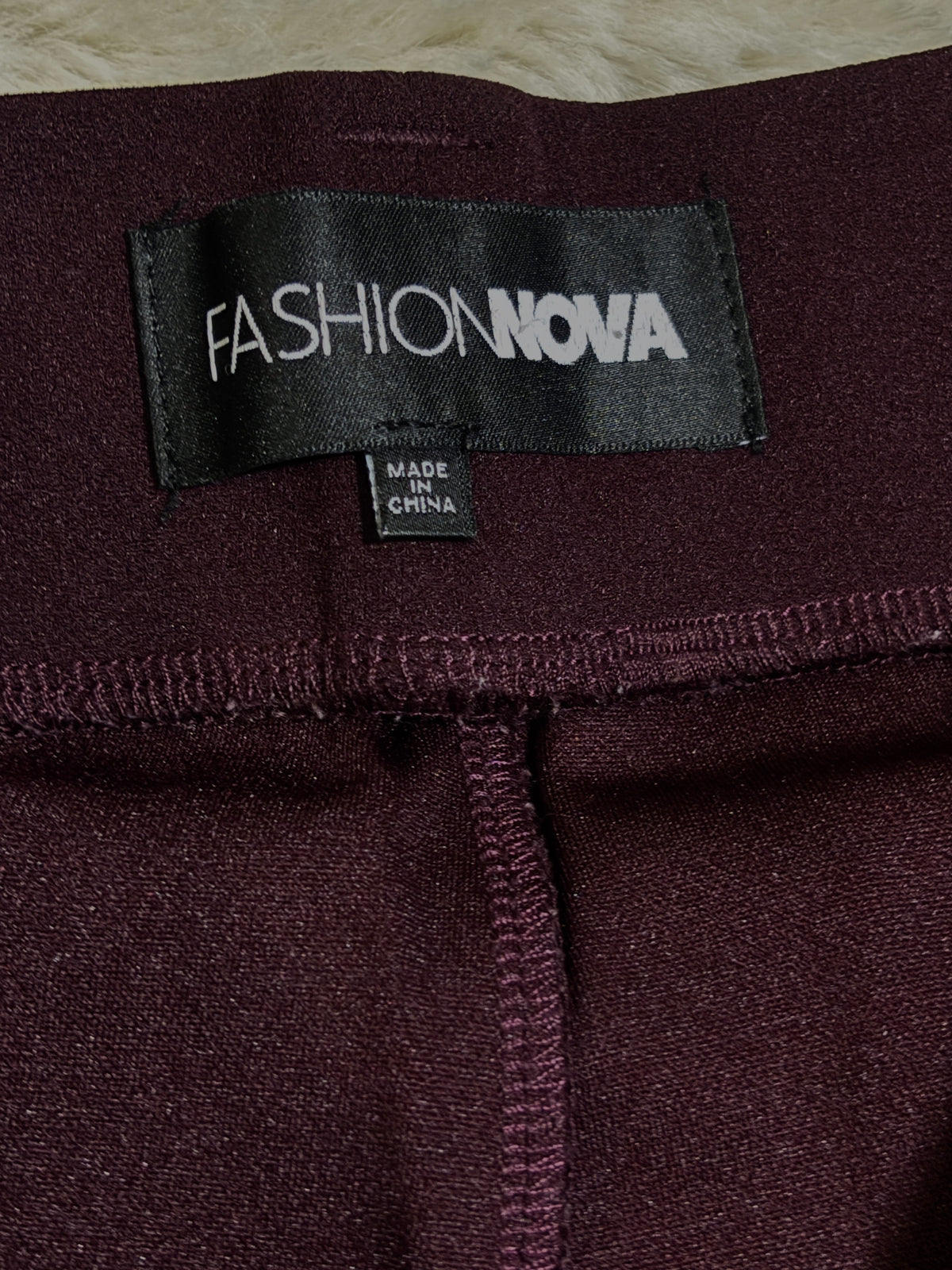 Fashion Nova label inside burgundy trousers