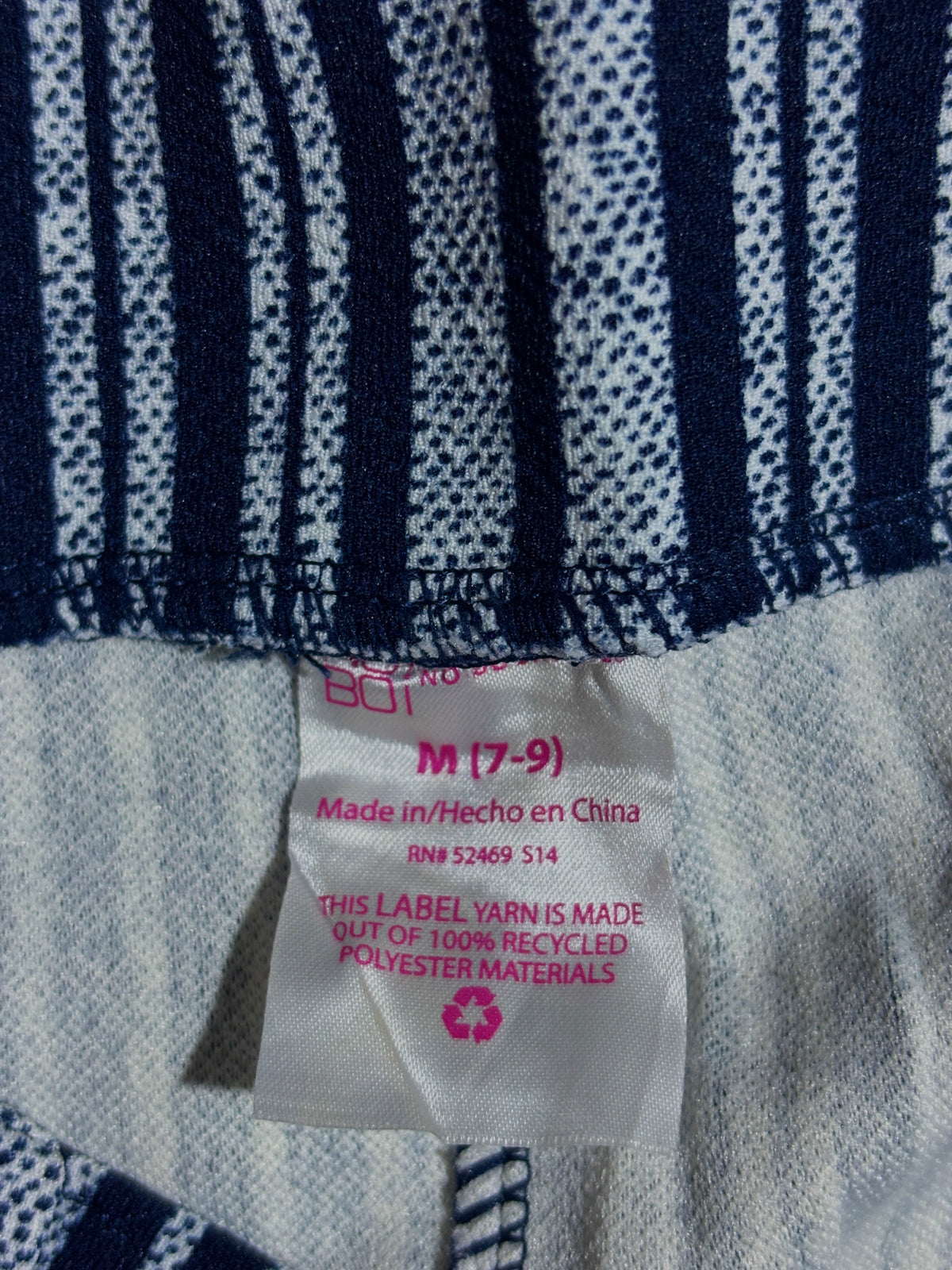 Size M 7-9 label and recycled polyester label on striped trousers
