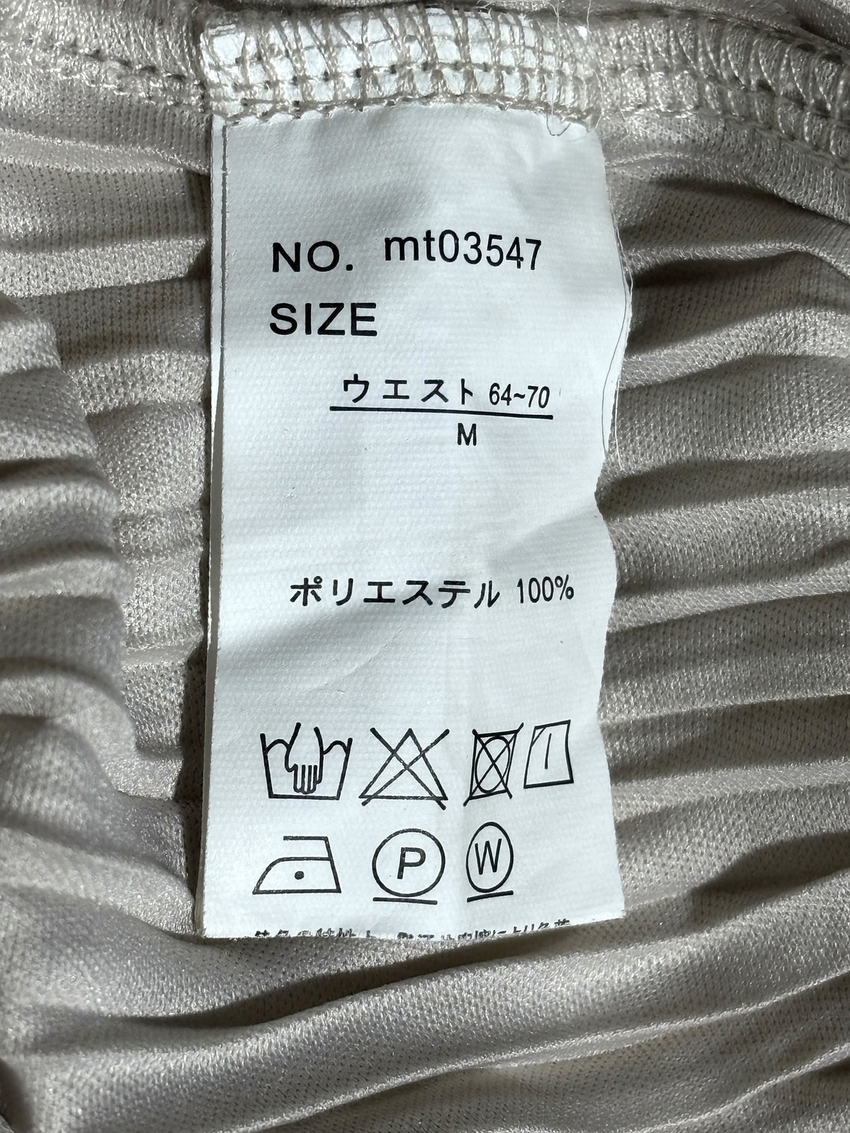 Size M and 100% polyester label inside silver pleated trousers