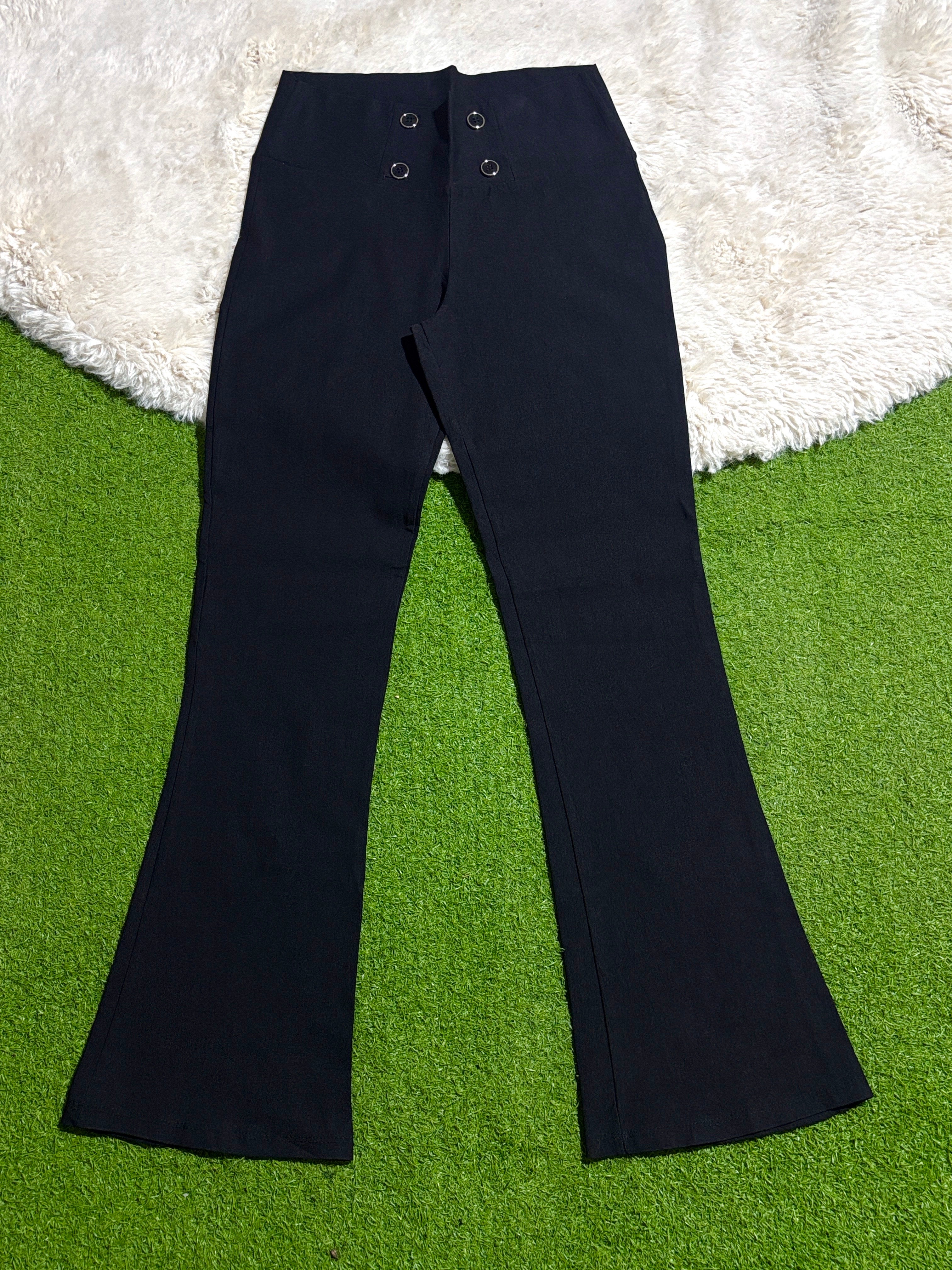Black flared trousers with four-button front detail laid flat
