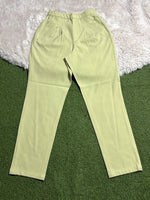 Pistachio green pleated tapered pants laid flat