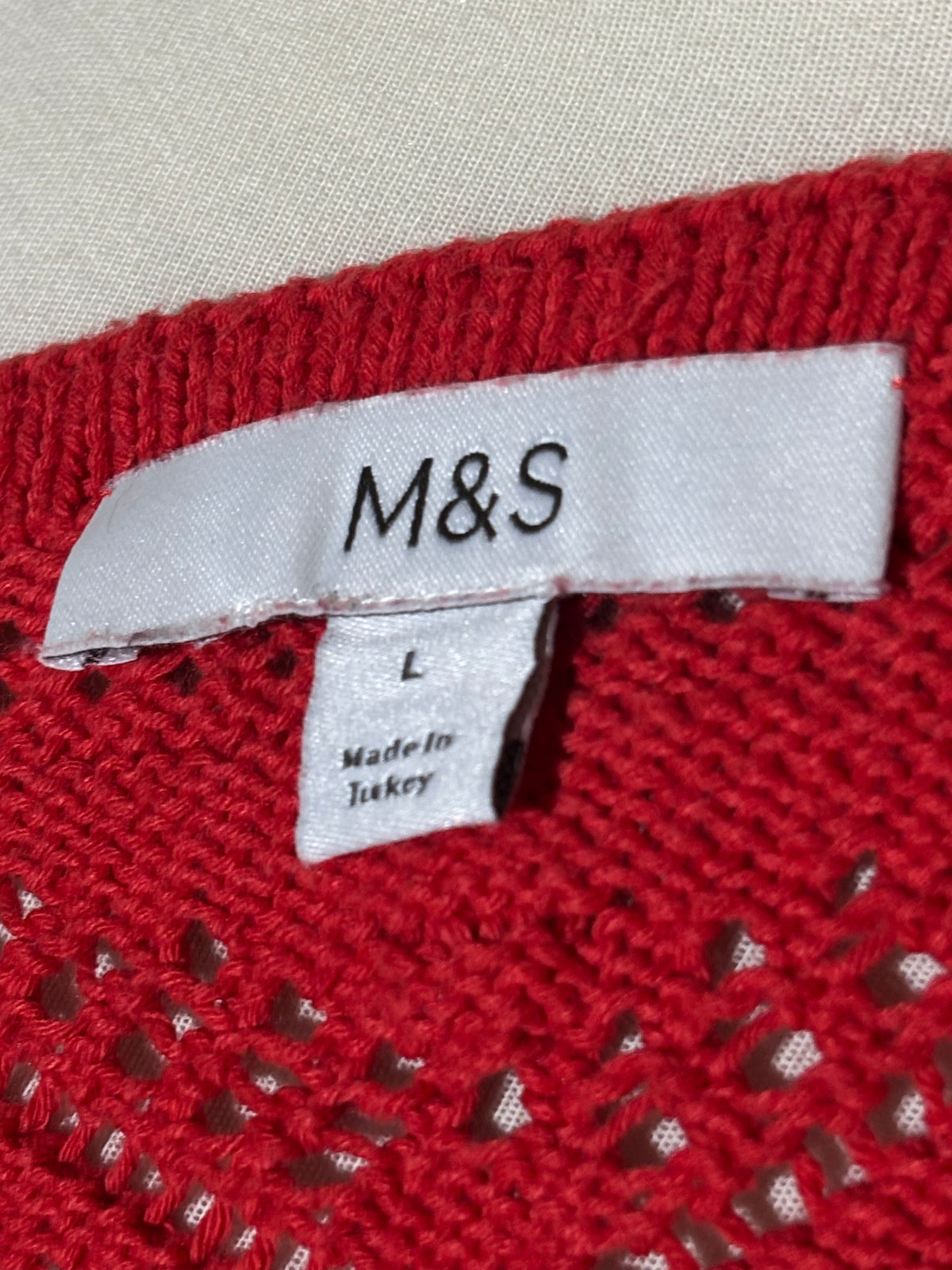 M&S size L label on red vest
