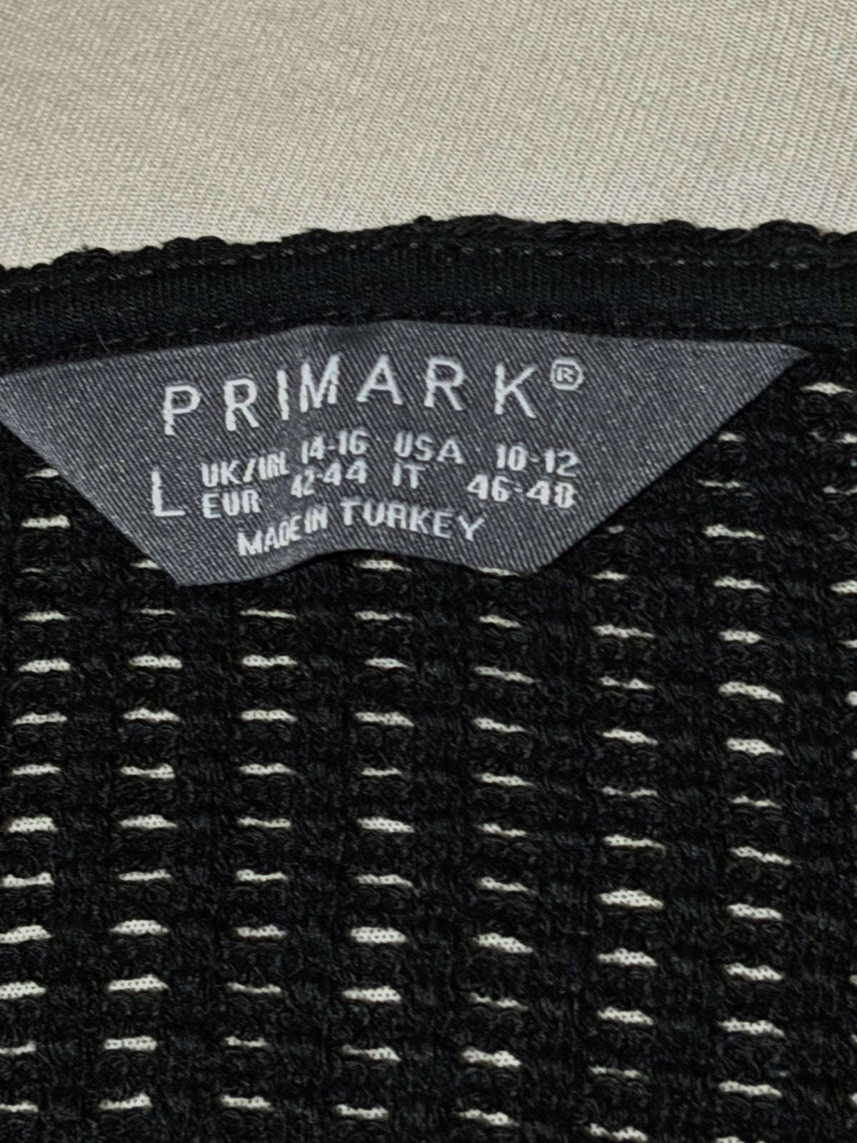Primark size L label on black openwork crop top
