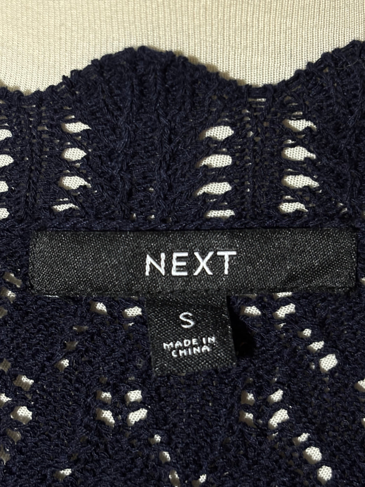 Next size S label on black vest