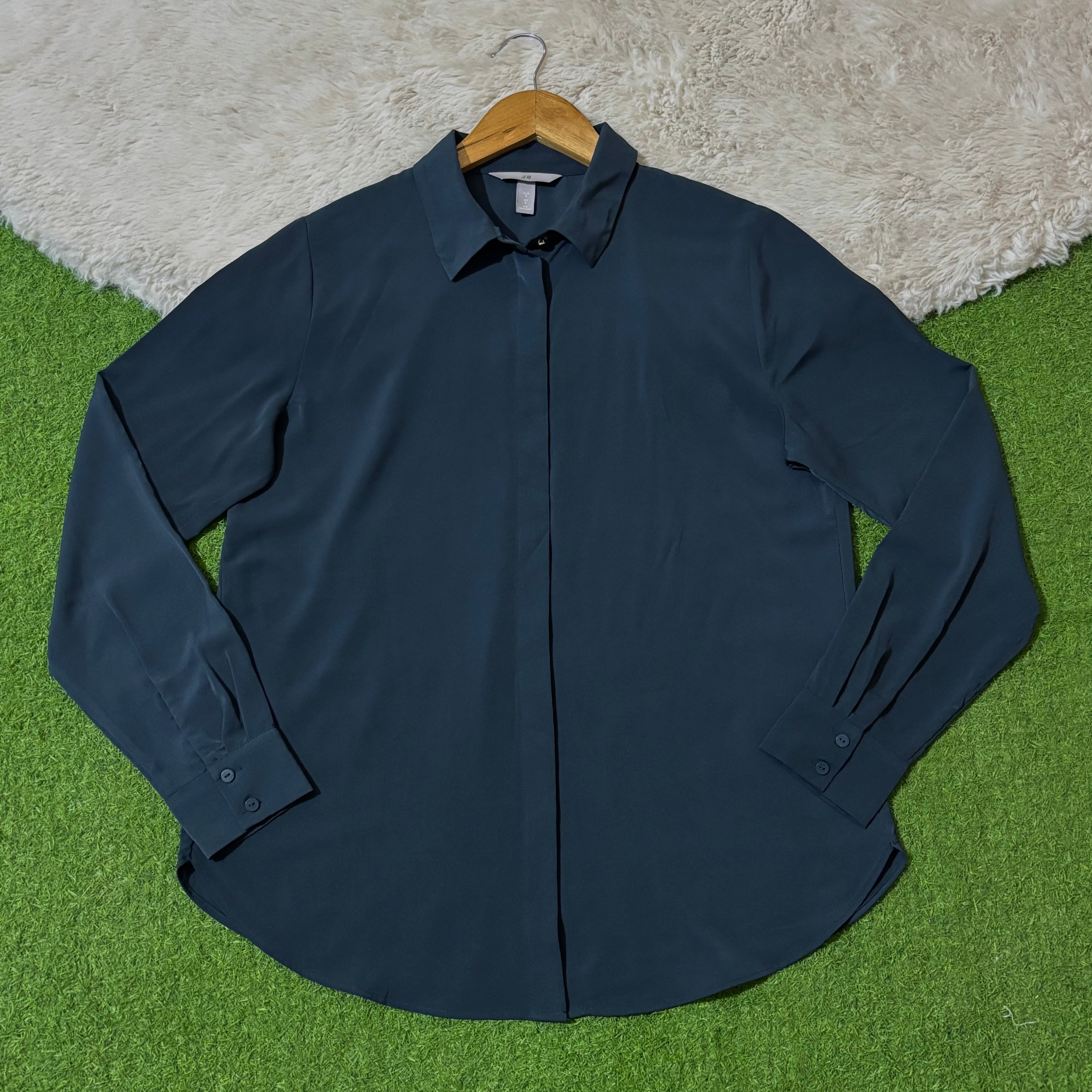 Navy blue concealed button-front shirt with pointed collar and long cuffed sleeves