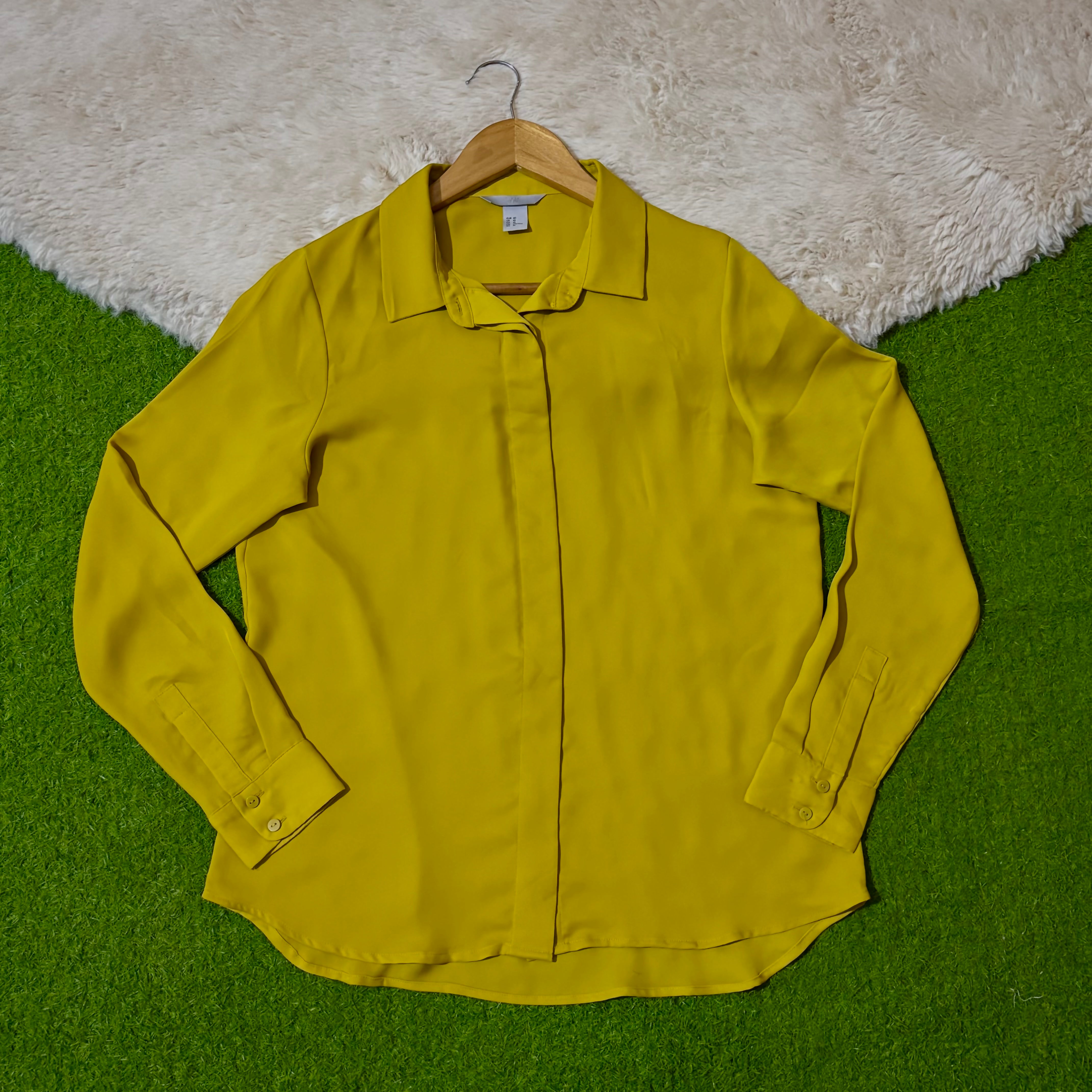 Mustard yellow collared shirt with concealed button front and long cuffed sleeves
