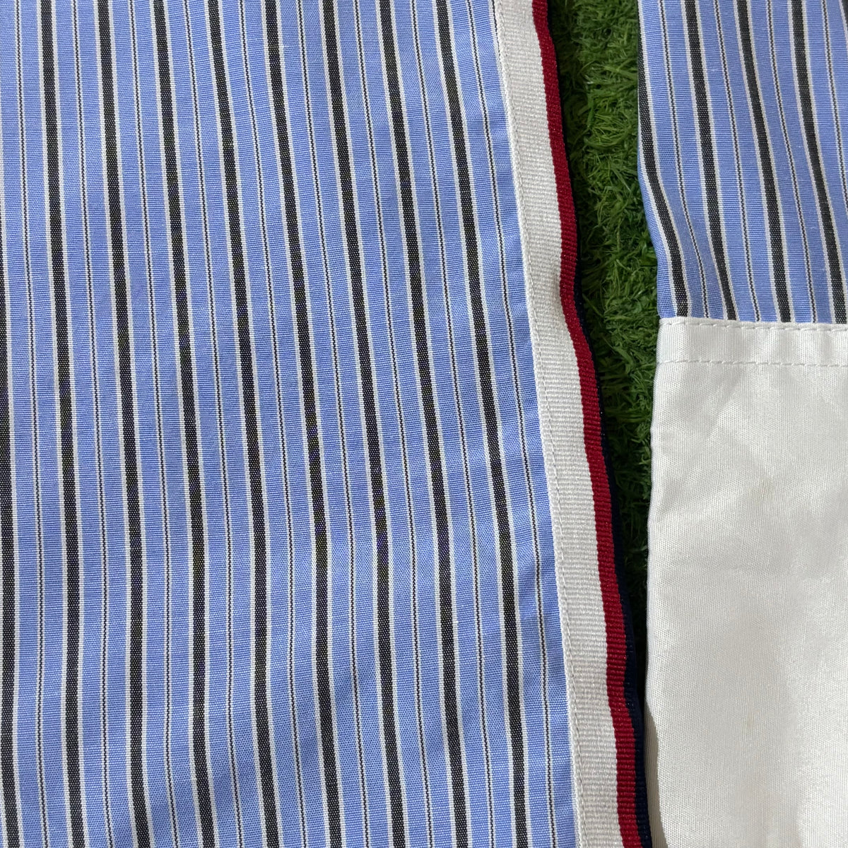 Close-up of striped shirt and contrasting side trim and white cuff