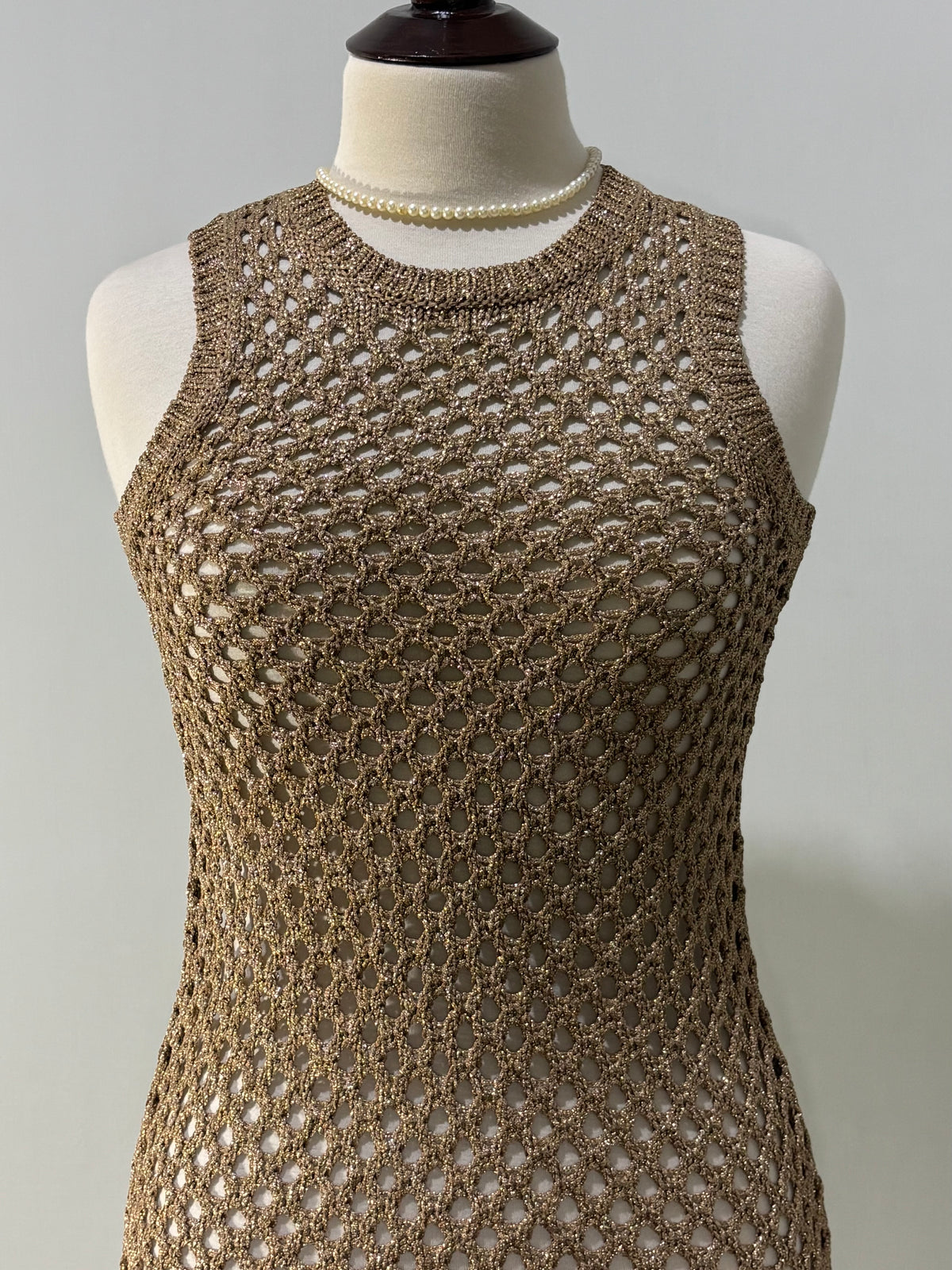 Gold openwork pattern and round neckline close-up