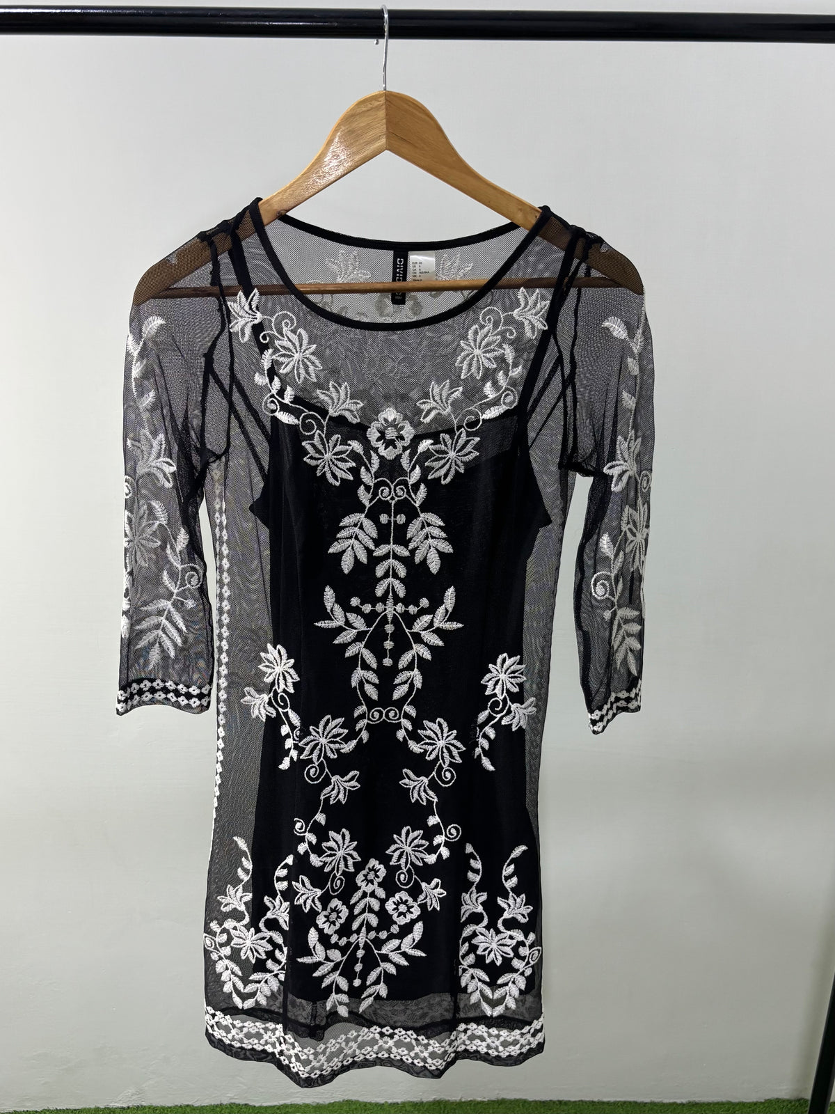 Black net dress with white floral embroidery and sheer sleeves