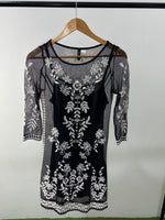 Black net dress with white floral embroidery and sheer sleeves