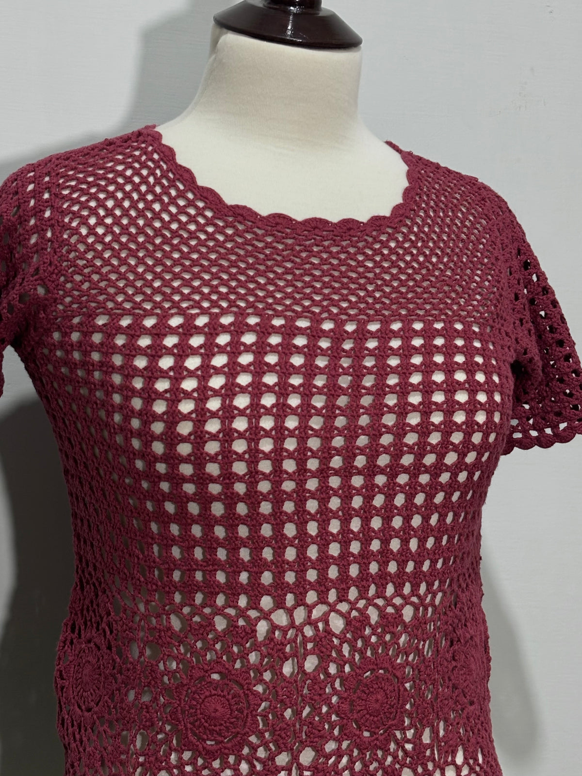 Close-up of dusty rose floral openwork and scalloped neckline