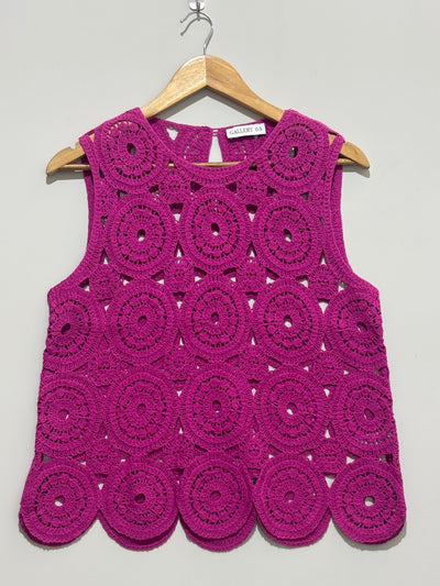 Magenta sleeveless top with circular openwork motifs and scalloped hem
