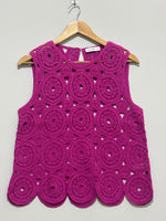 Magenta sleeveless top with circular openwork motifs and scalloped hem