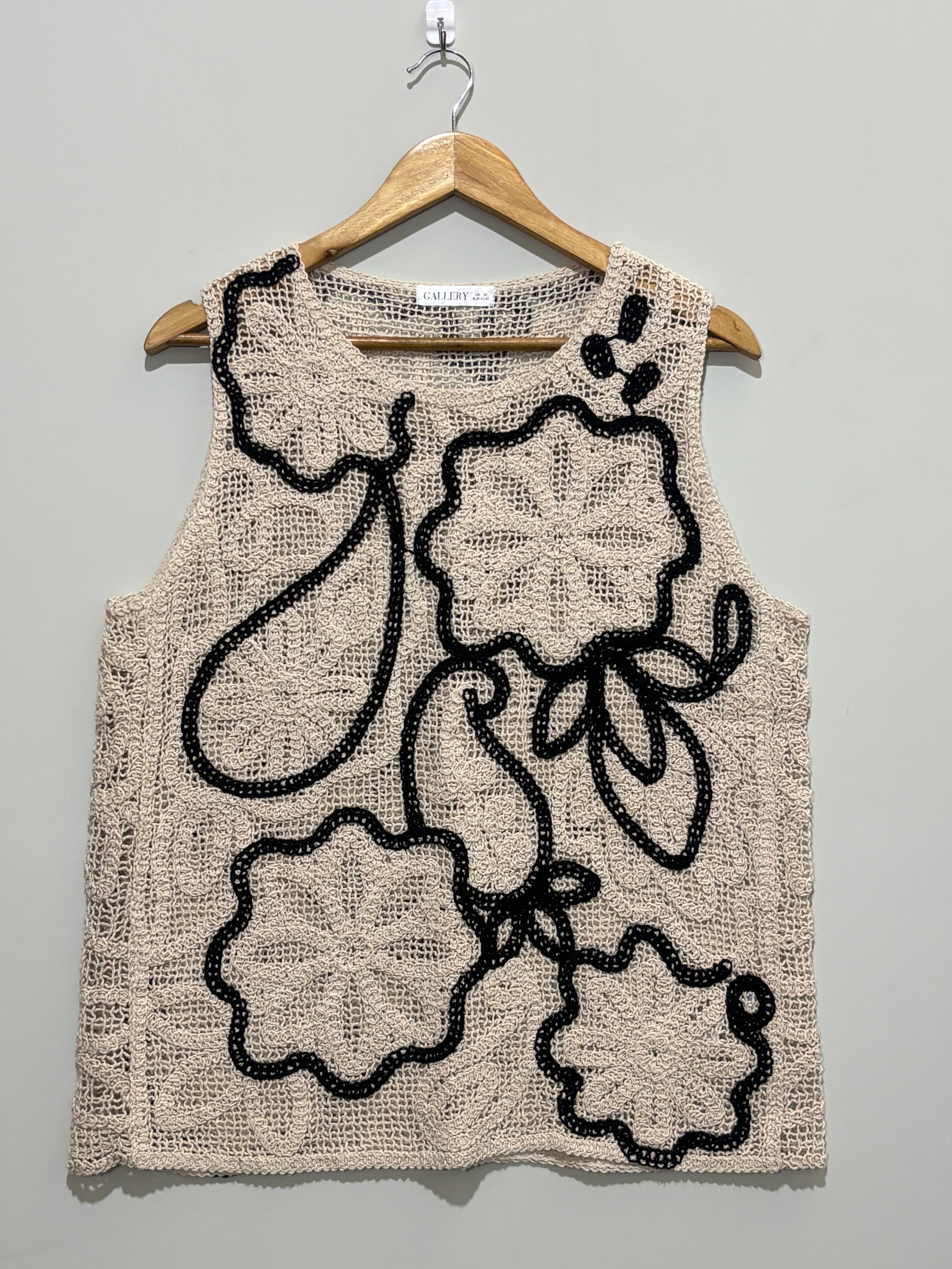 Beige openwork sleeveless top with black floral outlines