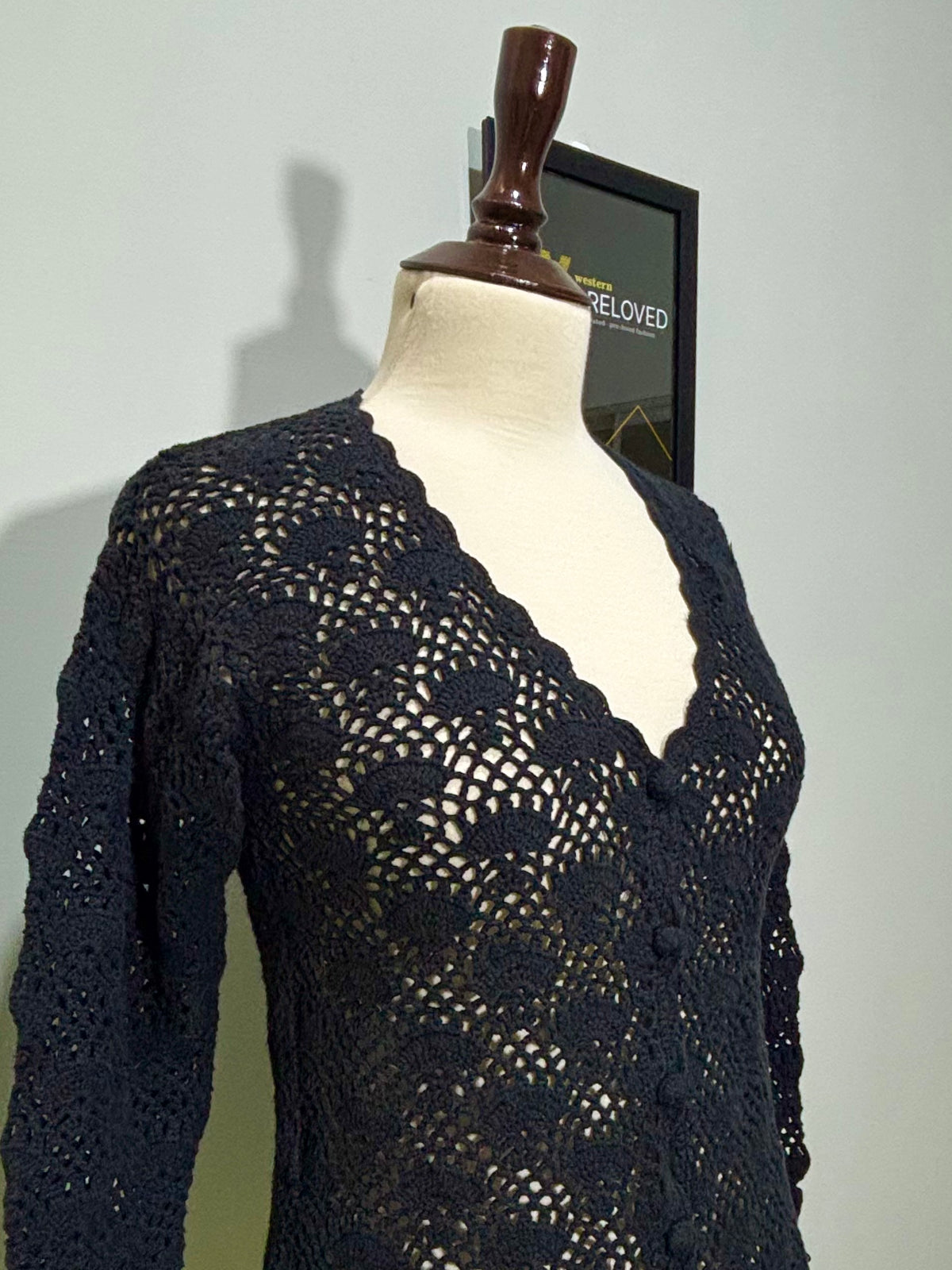 Side detail of black floral openwork long-sleeve top