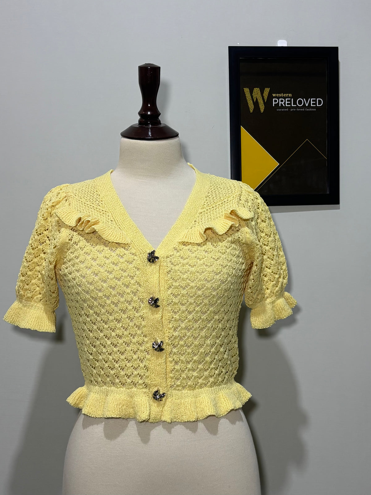 Side view of light yellow V-neck ruffle-trim top