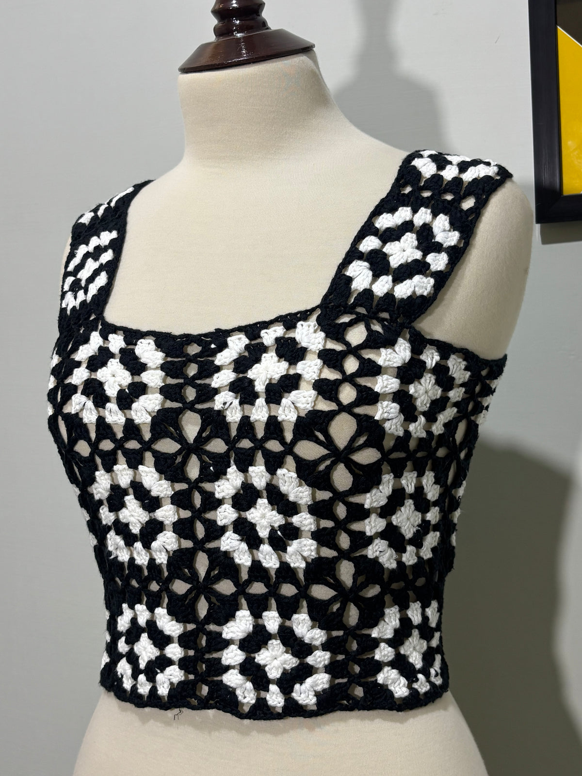 Side detail of black and white floral openwork crop top