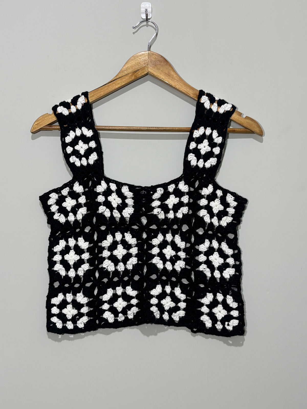 Black and white wide-strap openwork crop top on hanger
