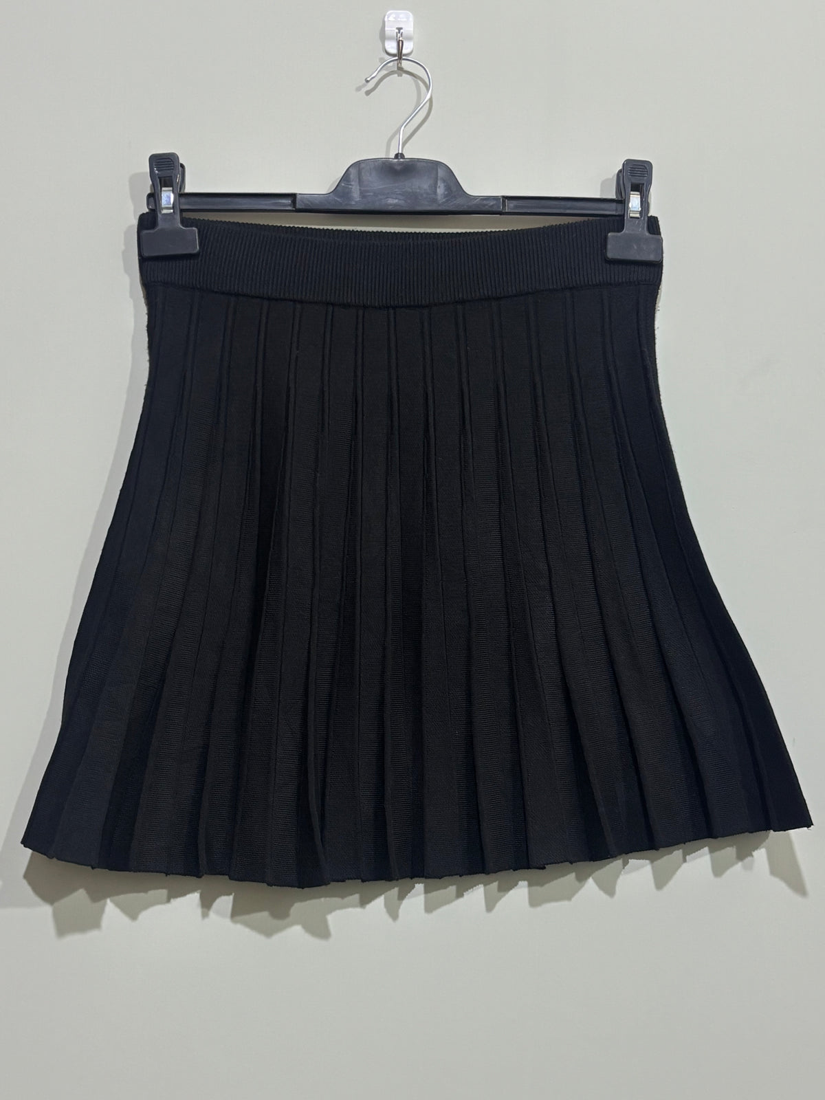 Black pleated A-line mini skirt with wide ribbed waistband