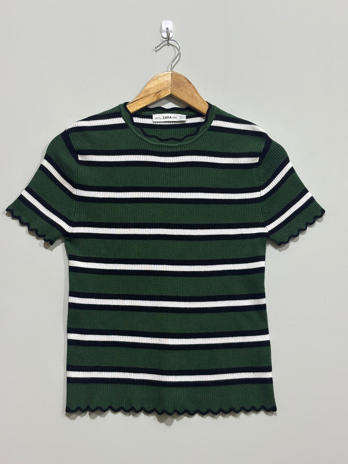 Striped ribbed top with scalloped sleeves and hem on hanger