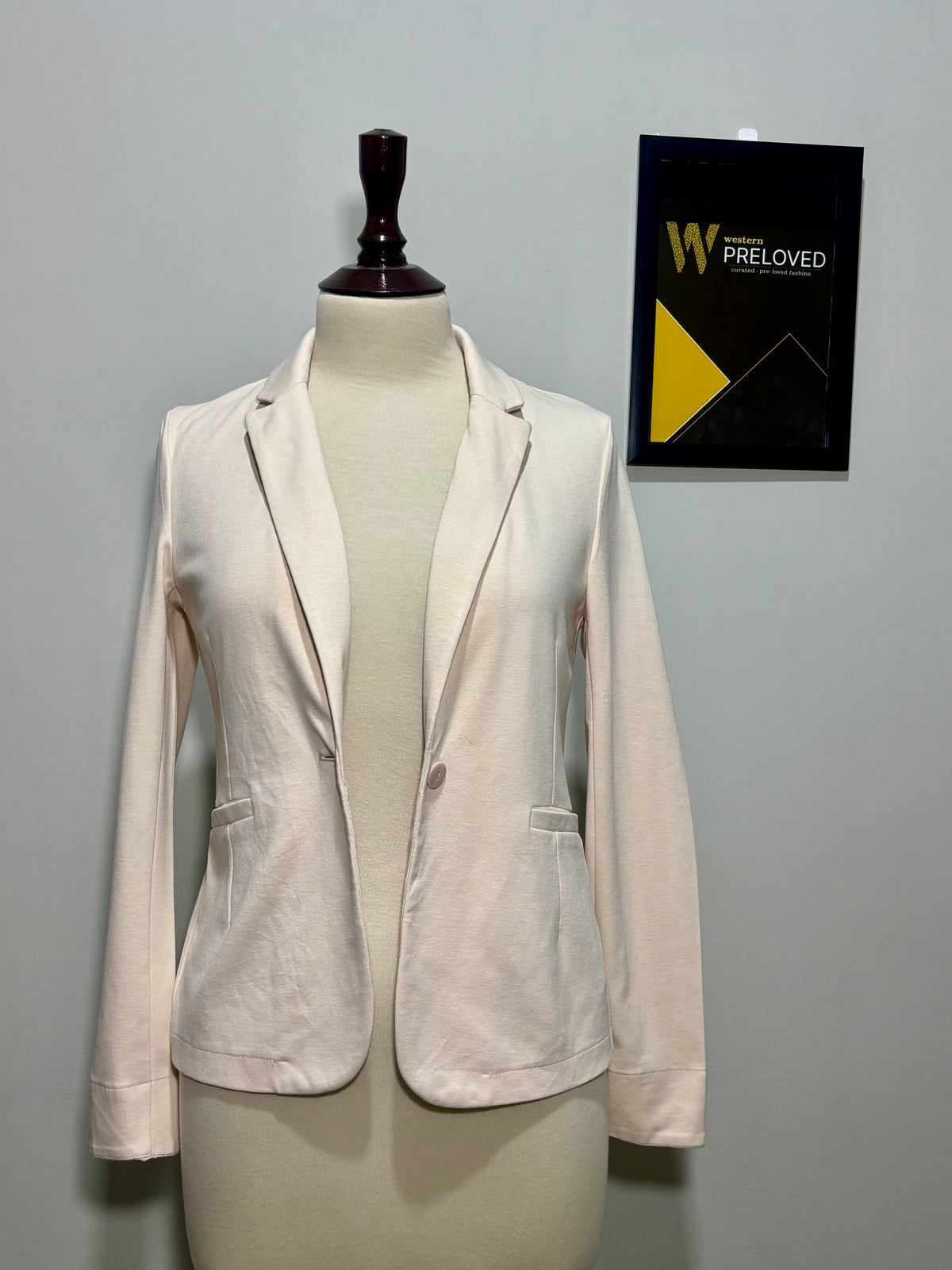 Cream single-button notched-lapel blazer on mannequin