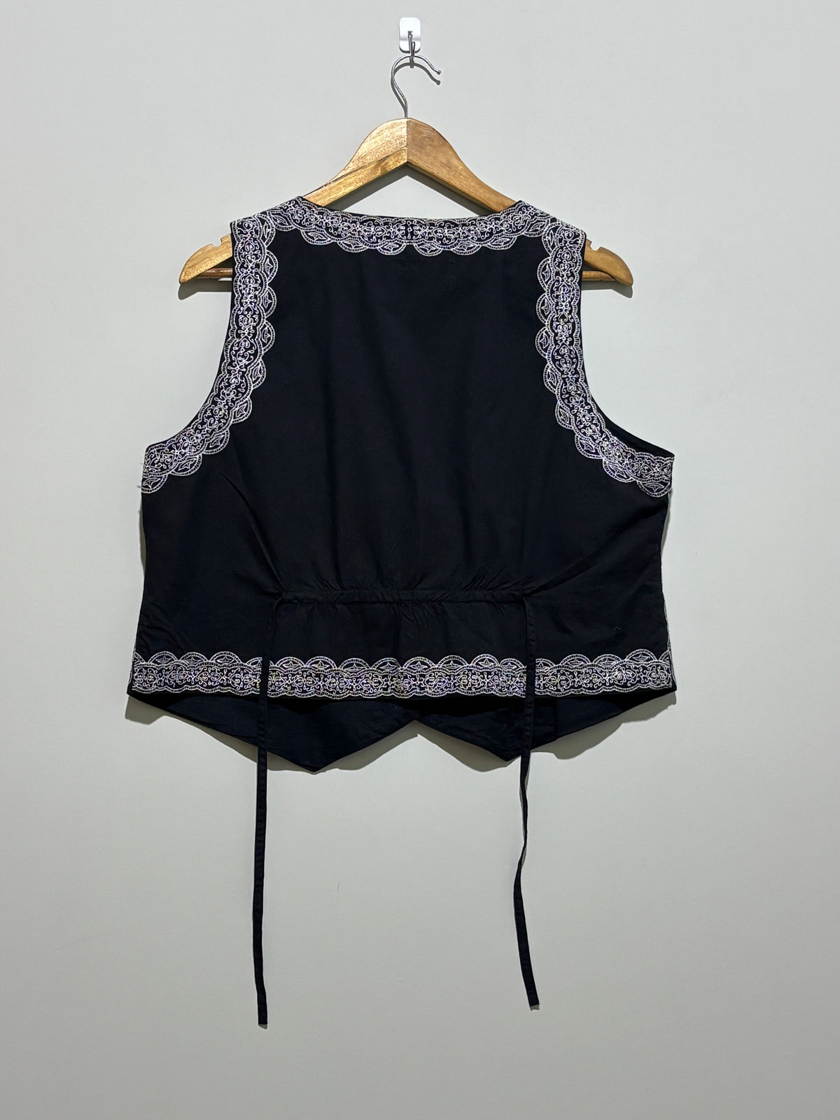 Back of black embroidered waistcoat with waist ties