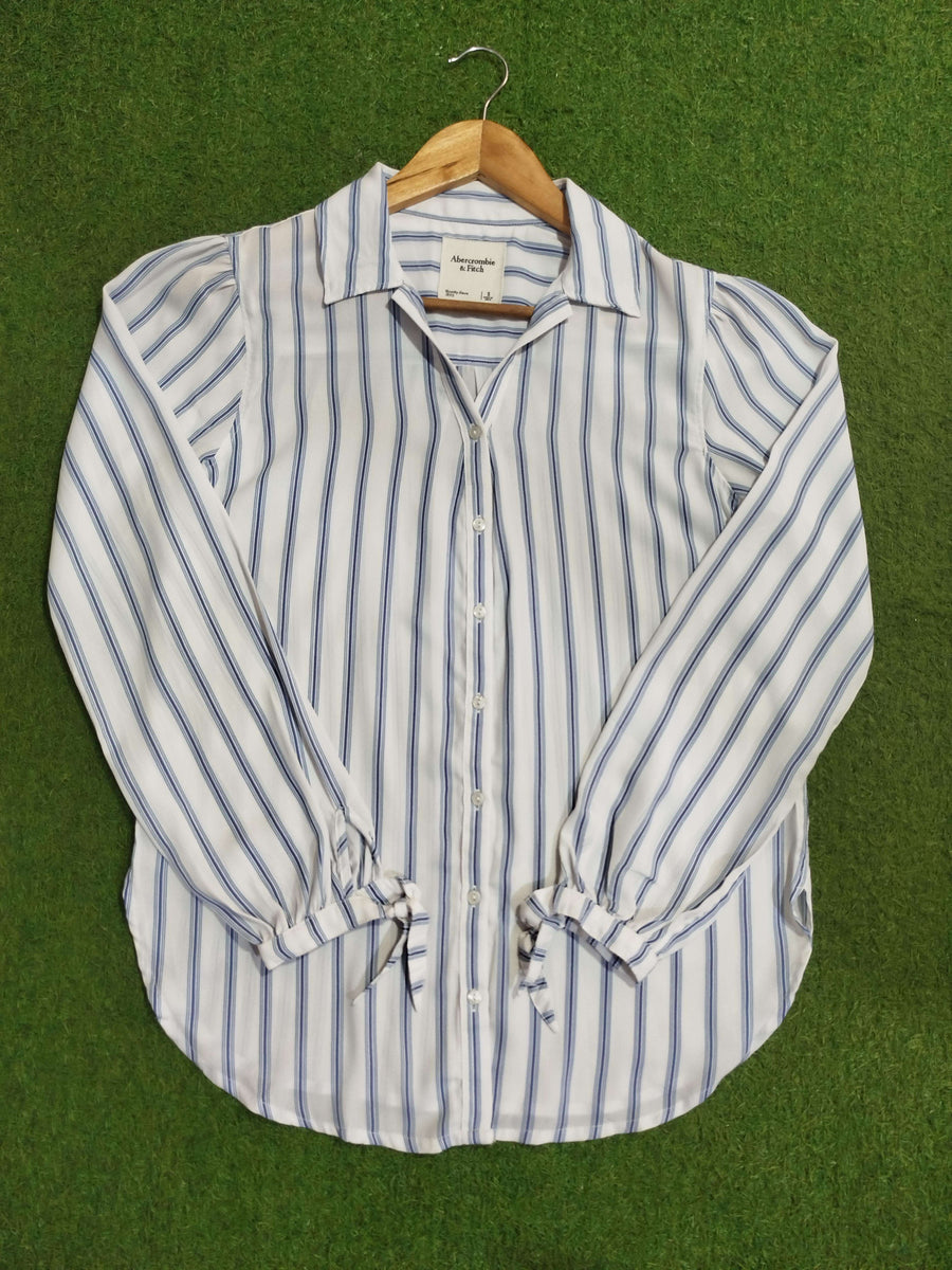 Striped shirt on a hanger against a green background - alternate view