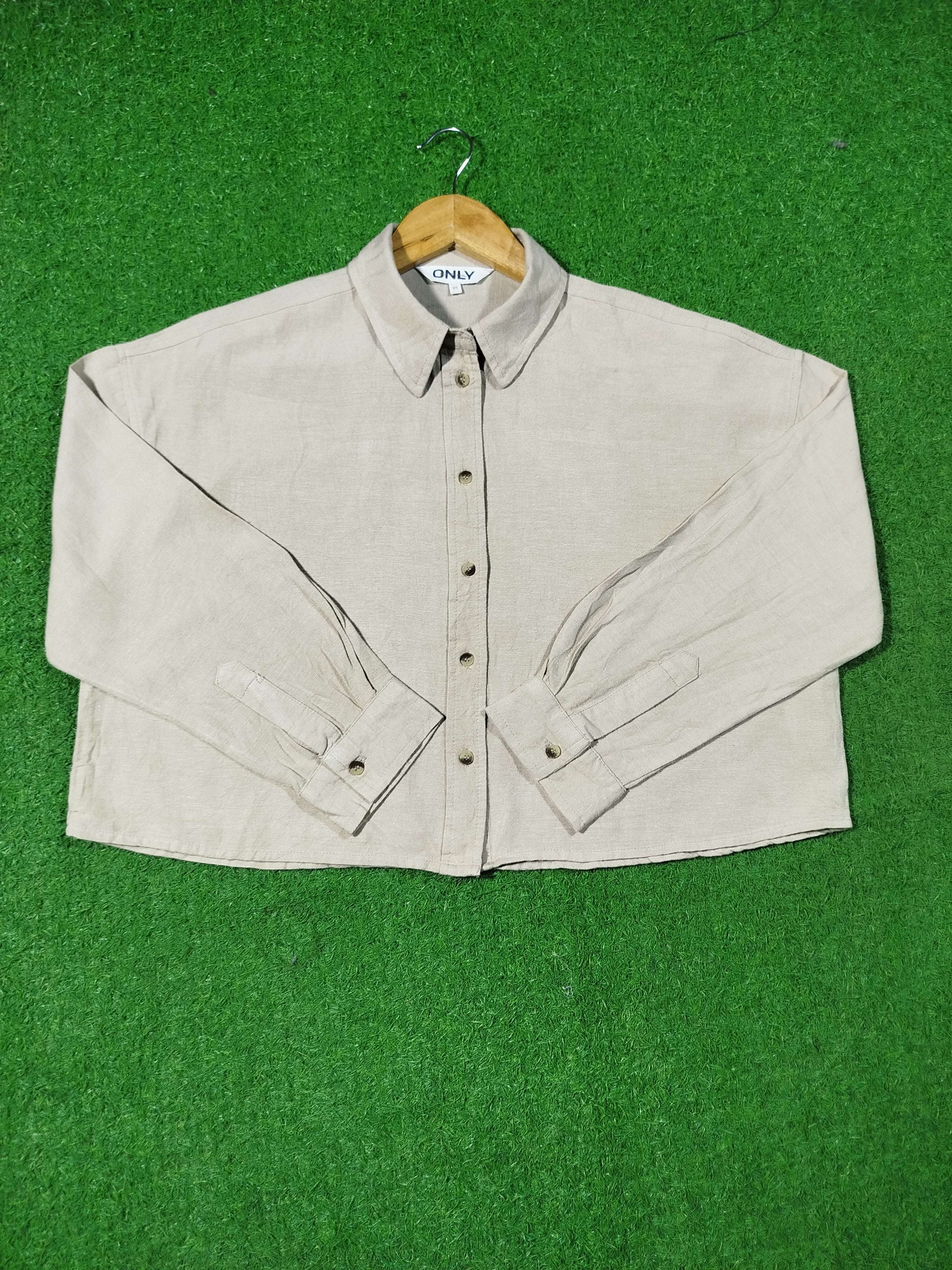 Beige shirt on a hanger against a green background