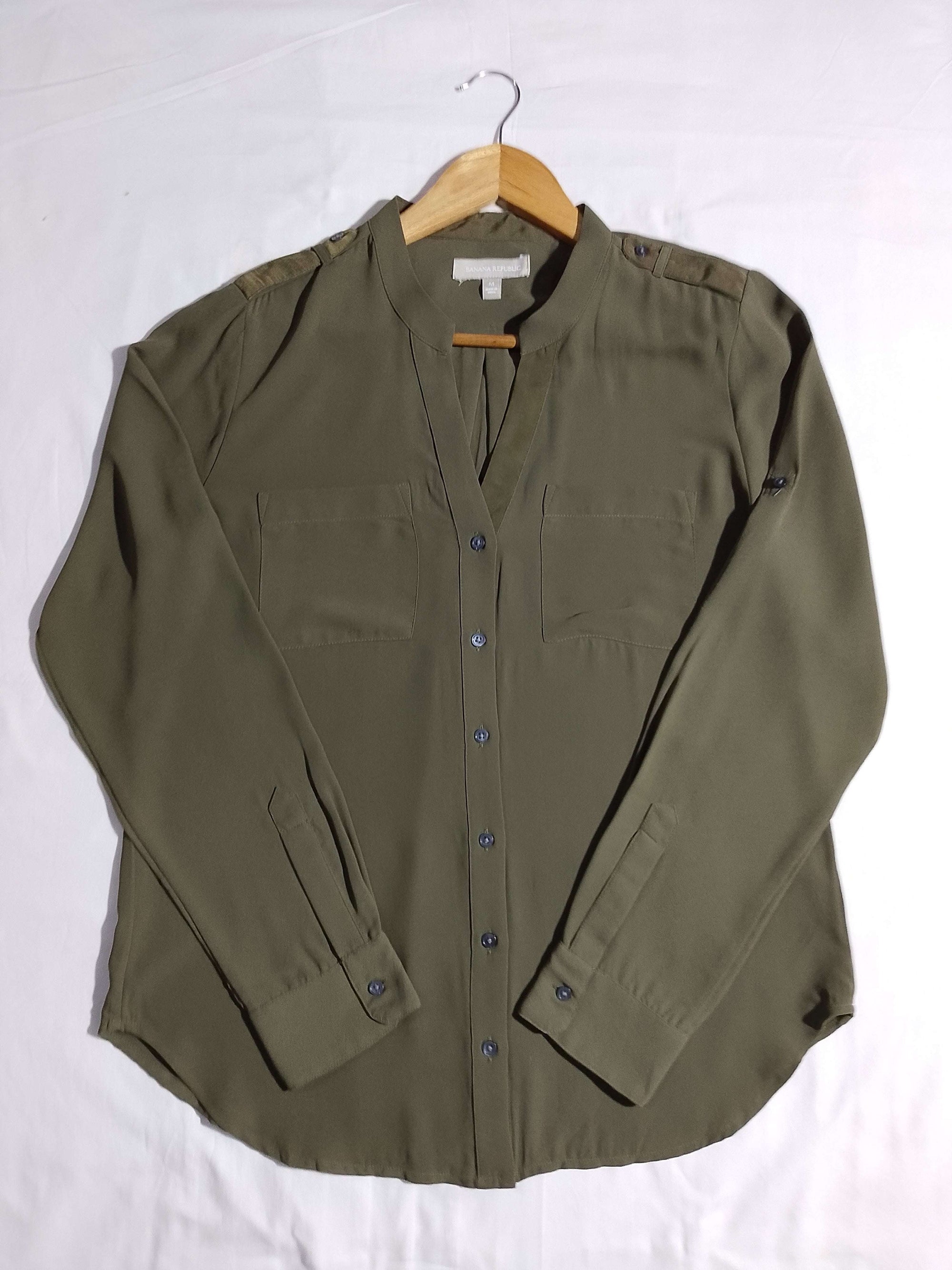 Green shirt on a hanger against a white background