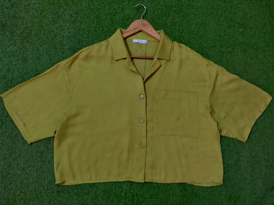Green shirt on a hanger against a green background - alternate view