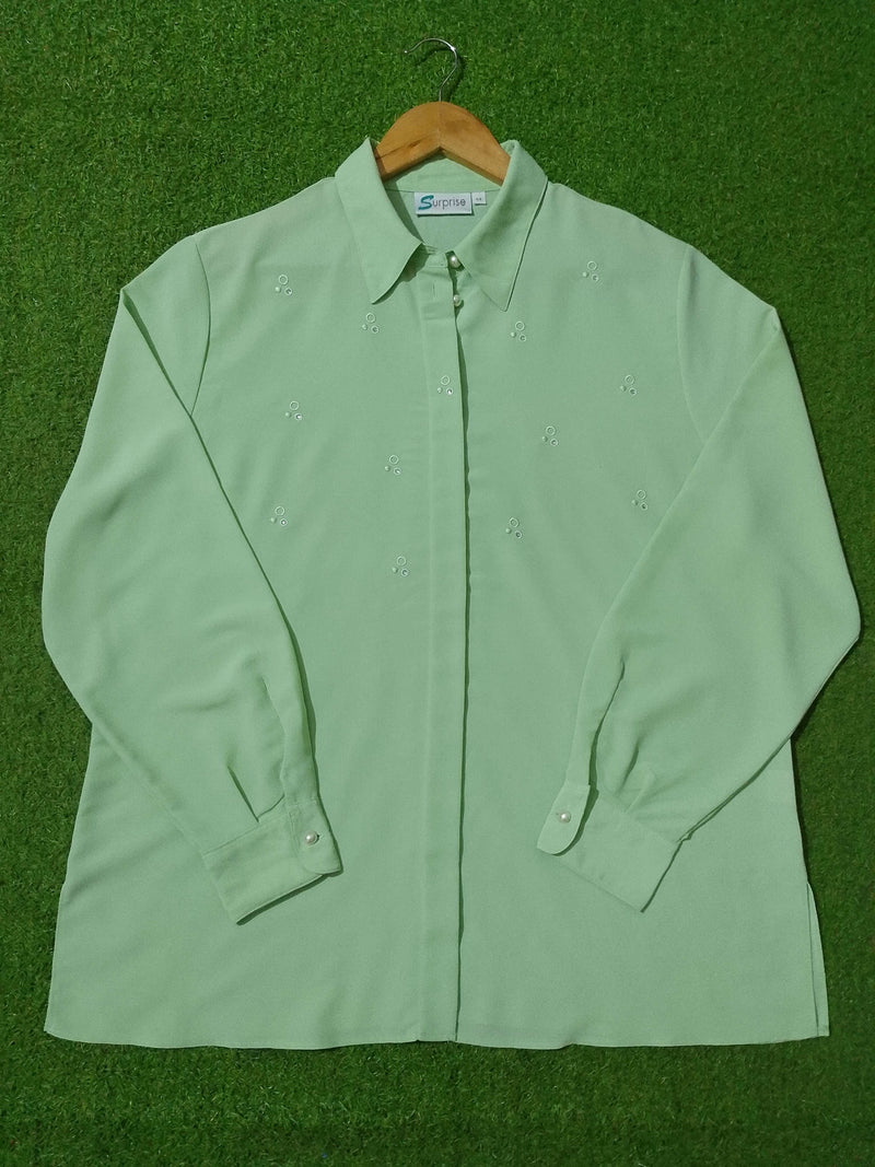 Light green shirt on a hanger against a green background