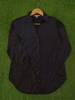 Black jacket on a hanger against a green grass background