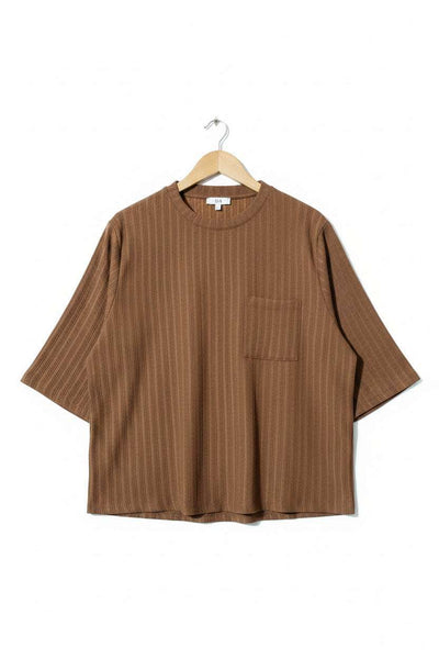 Brown shirt on a hanger against a green textured background - alternate view