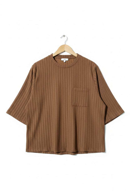 Brown shirt on a hanger against a green textured background - alternate view