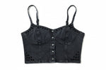 Black denim crop top with button details on a green grass background