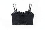 Black crop top with white embellishments on a green grass background