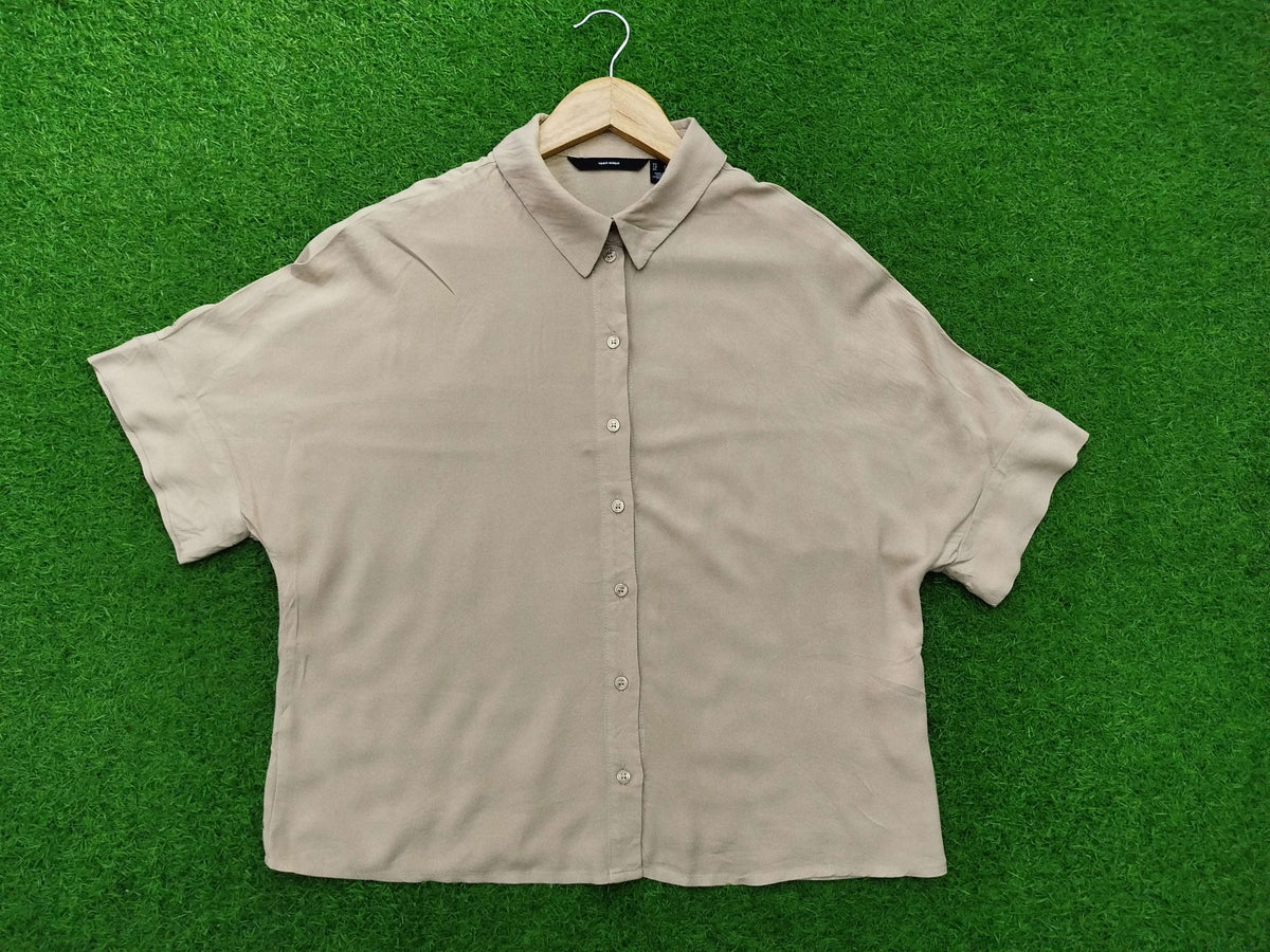 Beige short-sleeve shirt on a hanger against a green background
