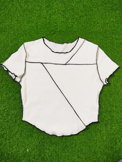White fabric with black lines on a green grass background - alternate view