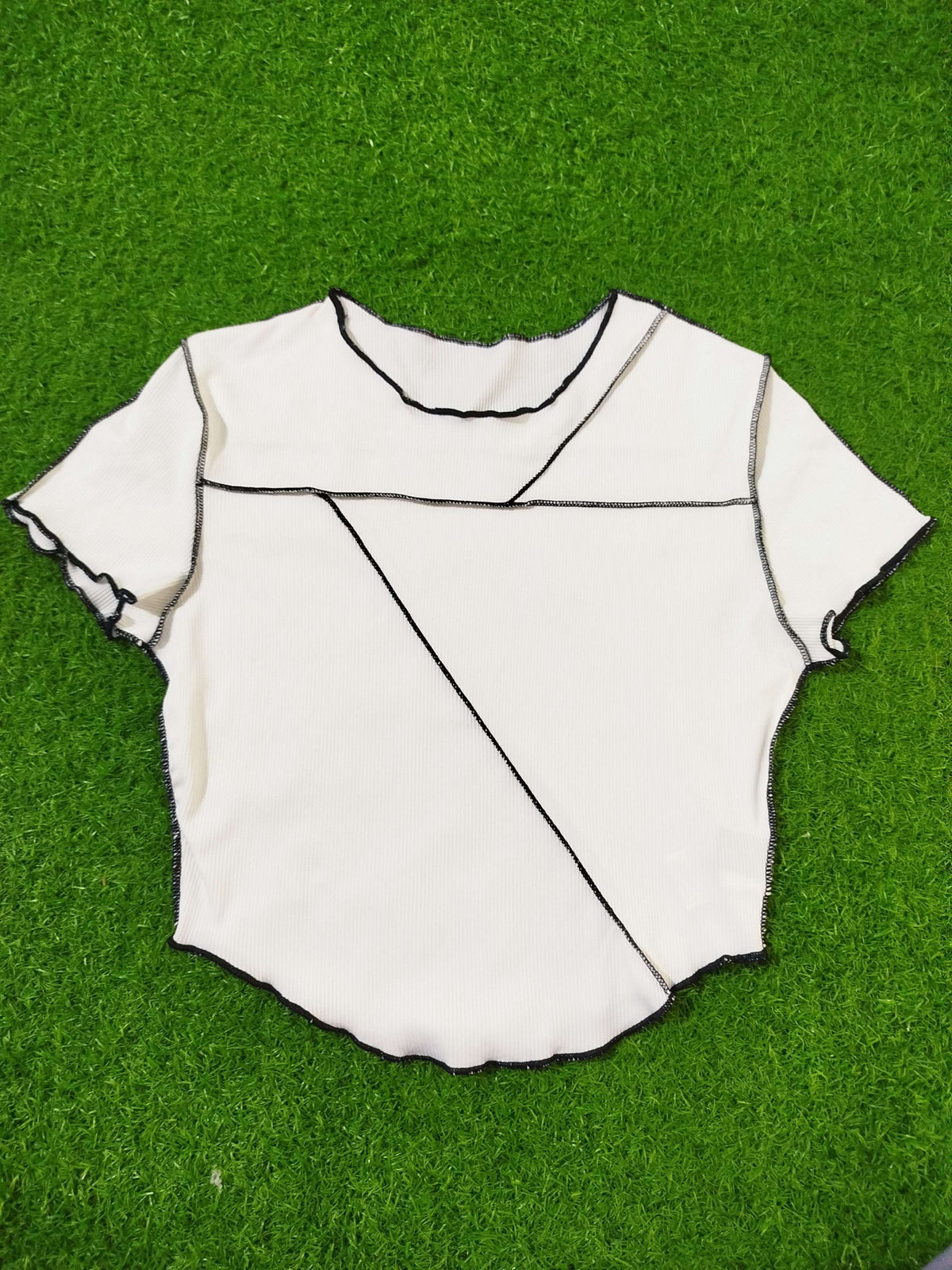 White fabric with black lines on a green grass background