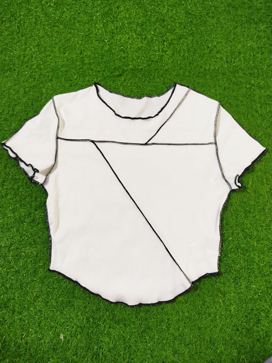 White fabric with black lines on a green grass background - alternate view