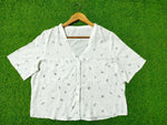 White fabric with small patterns on a green background