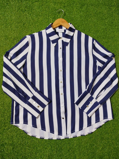 Navy and white striped shirt on a hanger against a green grass background