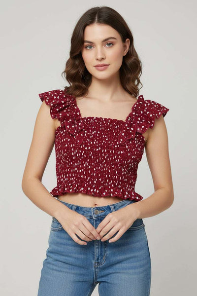 Red floral top with ruffled straps on a green grass background