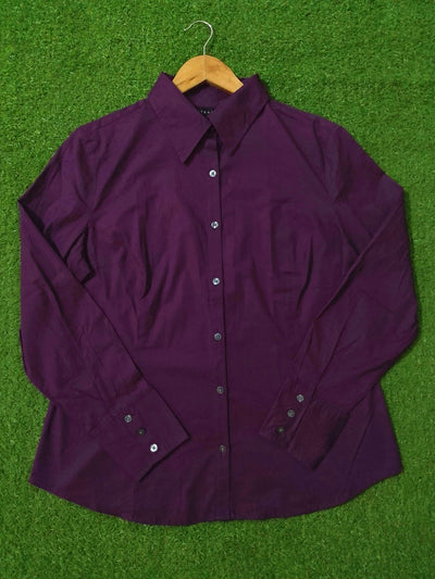 Purple shirt on a wooden hanger against a green grass background