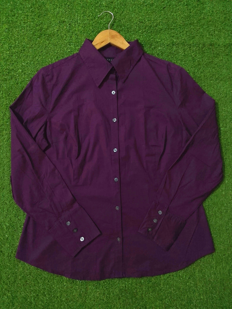 Purple shirt on a wooden hanger against a green grass background