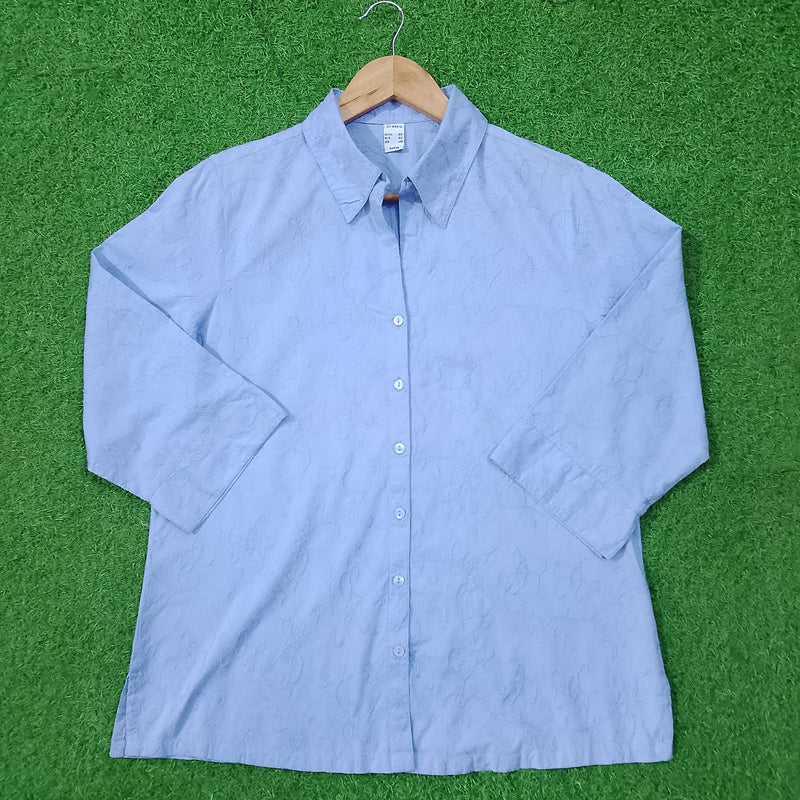 Blue button-up shirt on a green surface