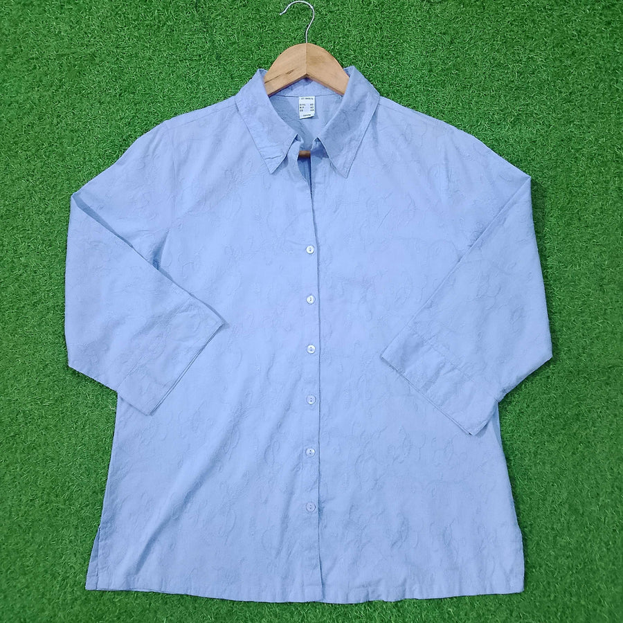 Blue button-up shirt on a green surface